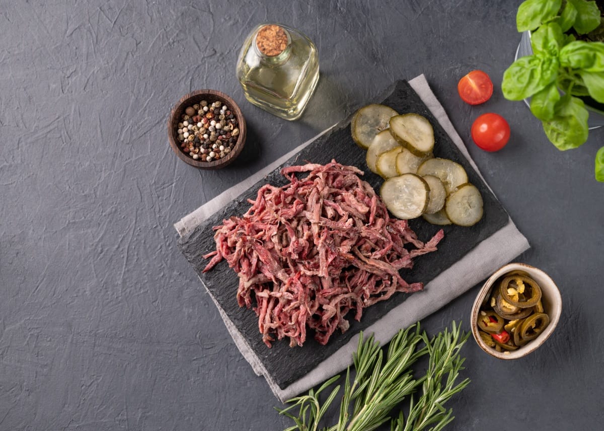 Viande de bœuf ou d'agneau déchirée au barbecue traditionnel sur ardoise noire avec jalapeno et concombre mariné