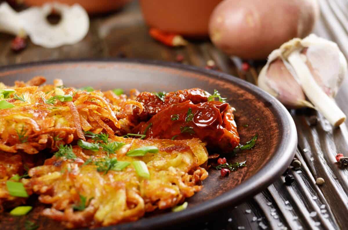 Vue rapprochée de crêpes de pommes de terre maison dans un plat en terre cuite avec