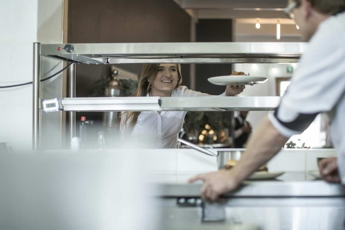 Waiter picking up food from the kitchen