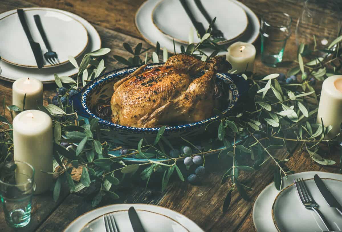 Whole roasted chicken for Christmas, plates and candles