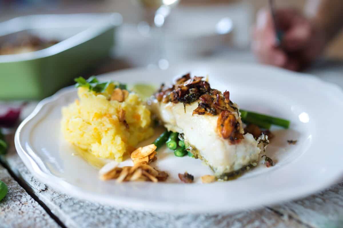 Zander fish fillet dish on a plate, wooden table